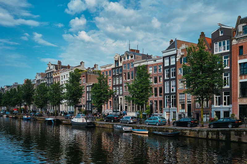 Widok na kanał w Amsterdamie z rzędem kamienic