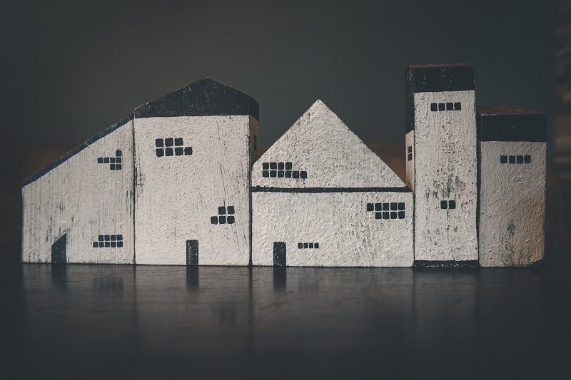 Rząd figurek przedstawiających budynki mieszkalne różnej wielkości